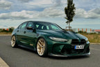 Alpha N G8X M3 M4 carbon front spoiler installed on vehicle, showcasing sleek exterior aerodynamic enhancement.
