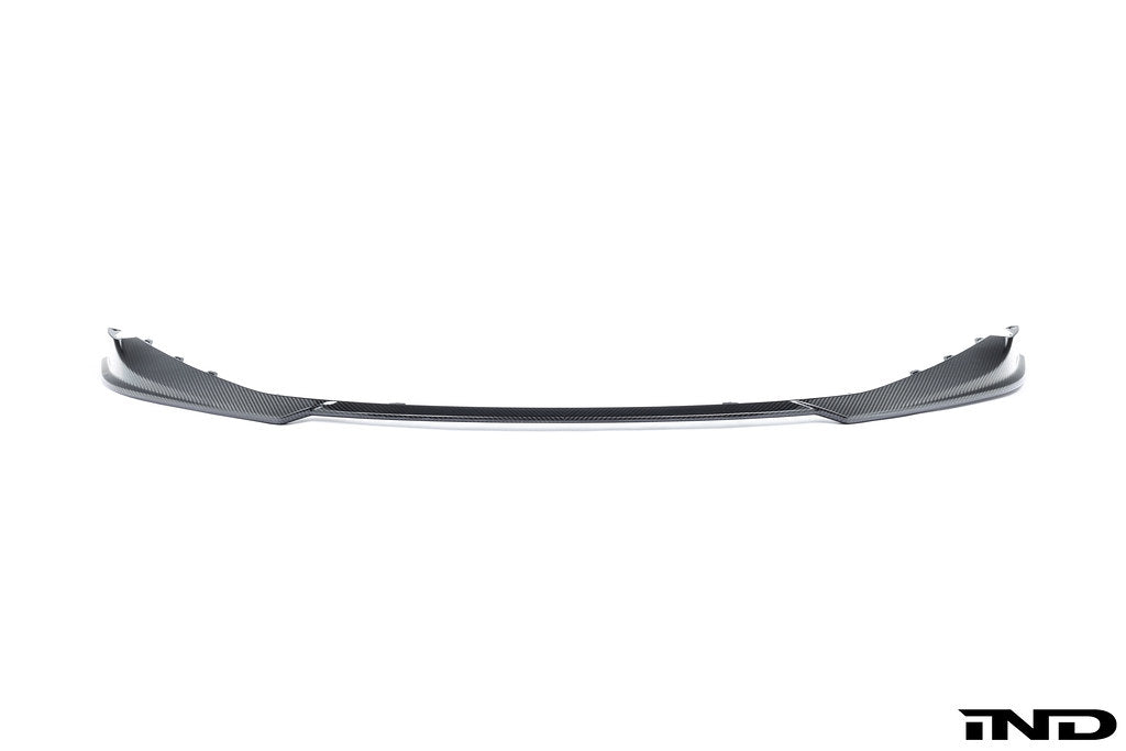 Alpha-N G8X M3 M4 carbon front spoiler mounted on a white background, showcasing its sleek exterior design.