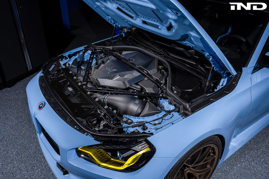 Alpha N G8X S58 carbon engine cover installed on BMW M2 M3 M4, exterior view showing sleek carbon finish and fitment