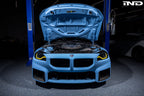 Alpha N G8X S58 carbon engine cover installed on a BMW M2, M3, or M4 exterior engine bay, showcasing sleek carbon fiber finish.