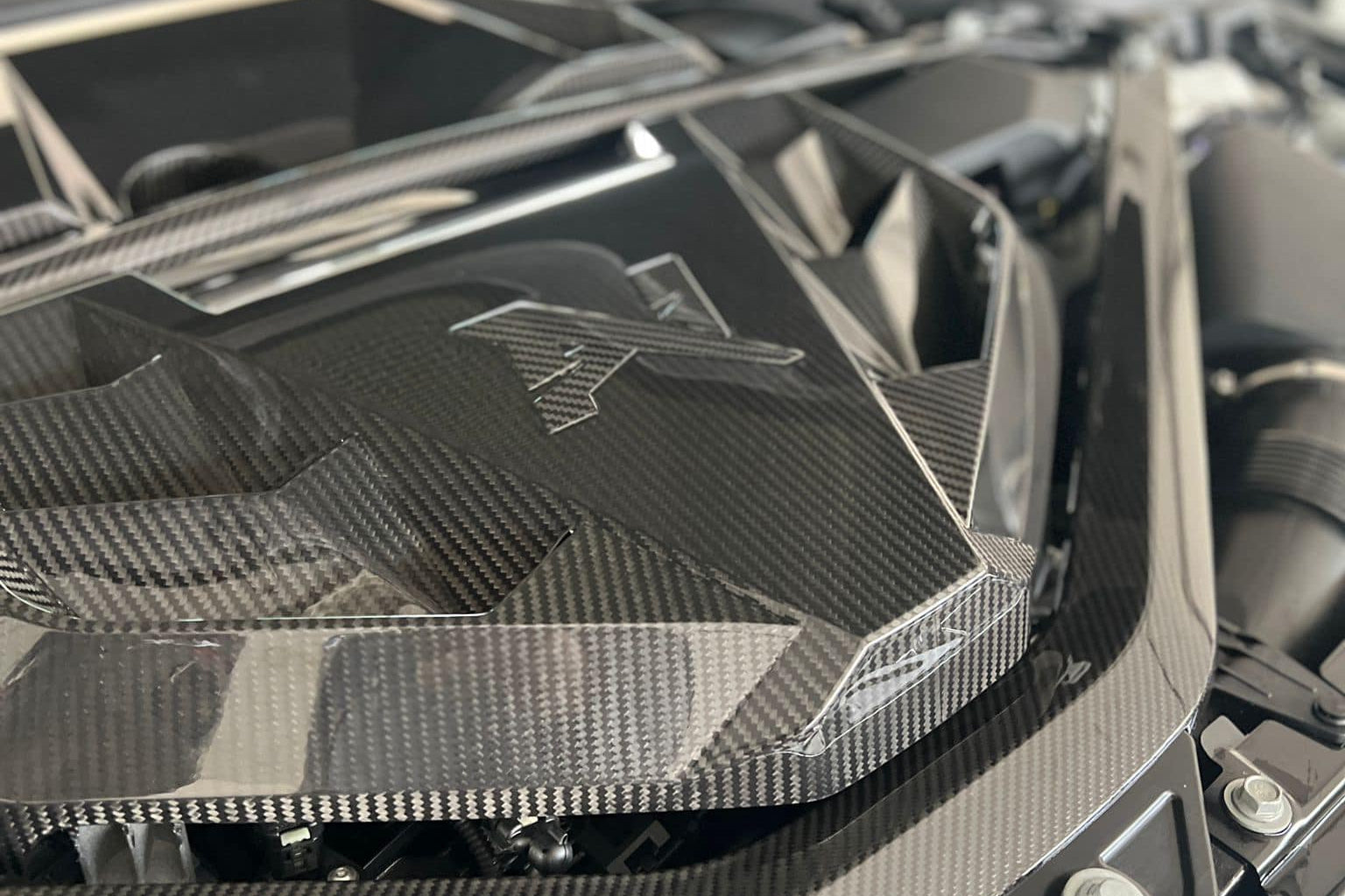 Alpha N G8X S58 carbon engine cover installed on exterior of M2, M3, or M4 BMW with sleek black carbon fiber finish.