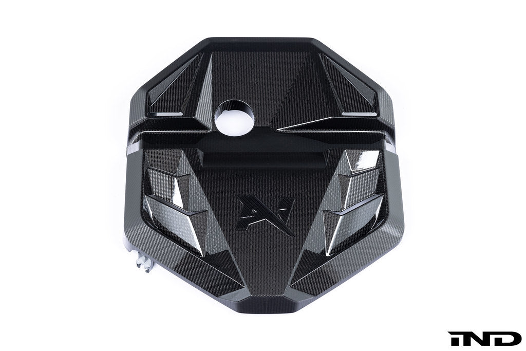 Alpha N G8X S58 carbon engine cover mounted on BMW G8X M2 M3 M4 exterior, white background showcasing sleek carbon fiber design.