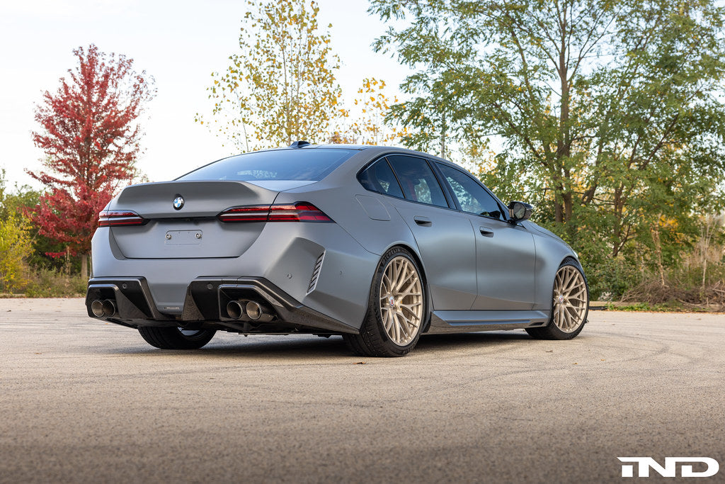 Alpha N G90 G99 M5 carbon rear diffuser installed on a vehicle, showcasing its sleek aerodynamic design and finish.