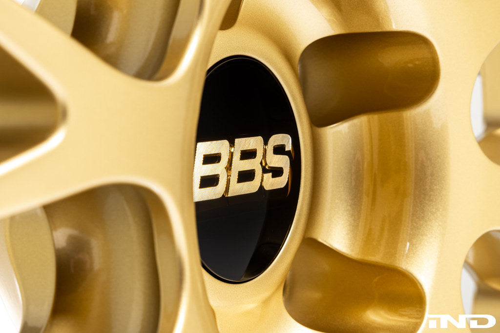 Close-up view of the contoured bolt pattern and pocketing on the BBS RT-88 forged aluminum wheel in a gold center finish; featuring a black center cap with gold BBS lettering.