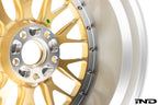 Close-up view of the rear face of the gold BBS RT-88 wheel showing the weight-saving machined mounting pad pockets as well as the bolts that fasten the wheel center to the barrel.