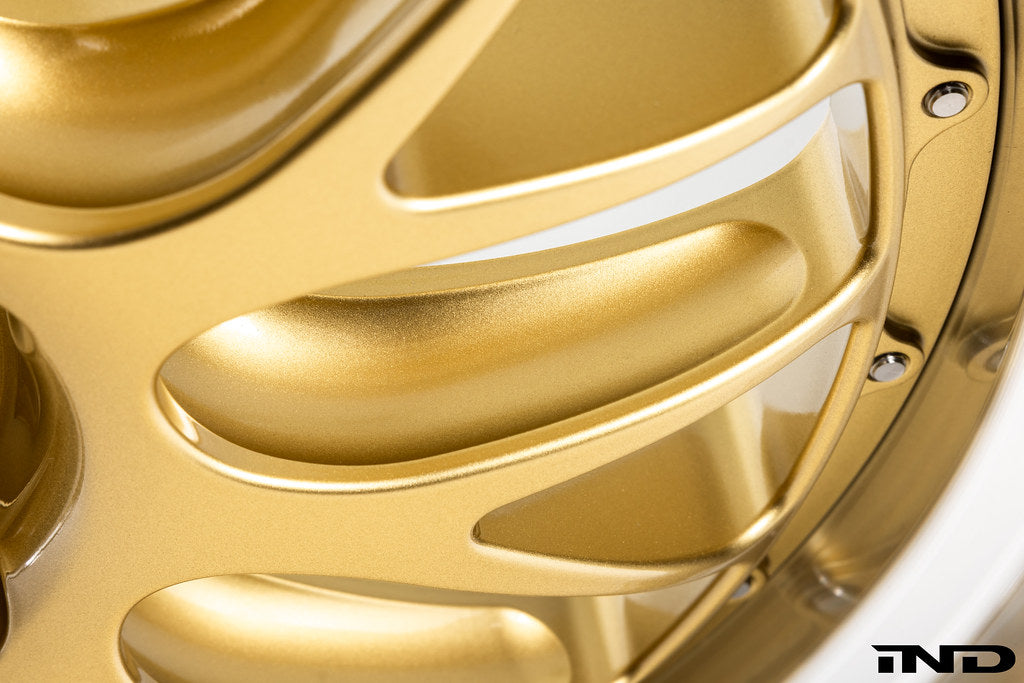 Close-up view of the pocketed spokes, hardware, and rim edge on the BBS RT-88 forged aluminum wheel in a gold center finish.