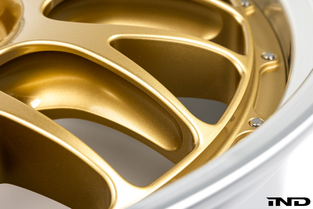 Close-up view of the pocketed spokes, hardware, and rim edge on the BBS RT-88 forged aluminum wheel in a gold center finish.