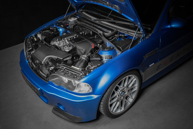 BMW E46 M3 Eventuri Carbon Airbox installation guide showing the complete carbon airbox and intake system installed on a blue E46 M3, highlighting the CSL-style induction setup and carbon fiber intake components.