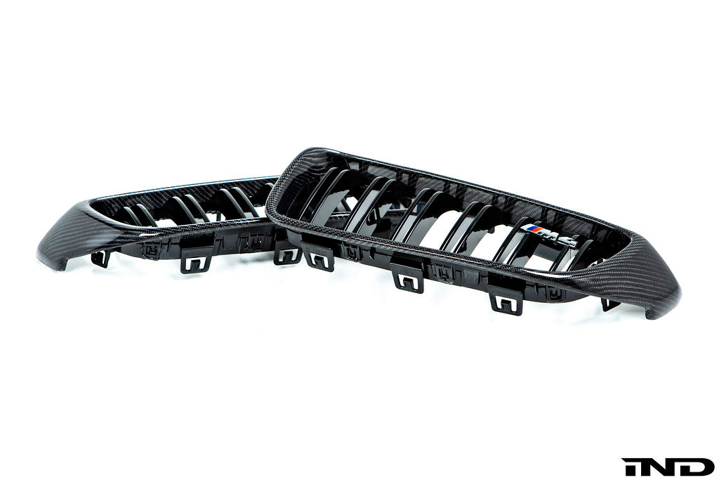 IND Carbon Fiber Front Grille Set for BMW F80 M3 and F82/F83 M4 featuring 2x2 carbon fiber surrounds with OEM BMW grille slats on a white background.