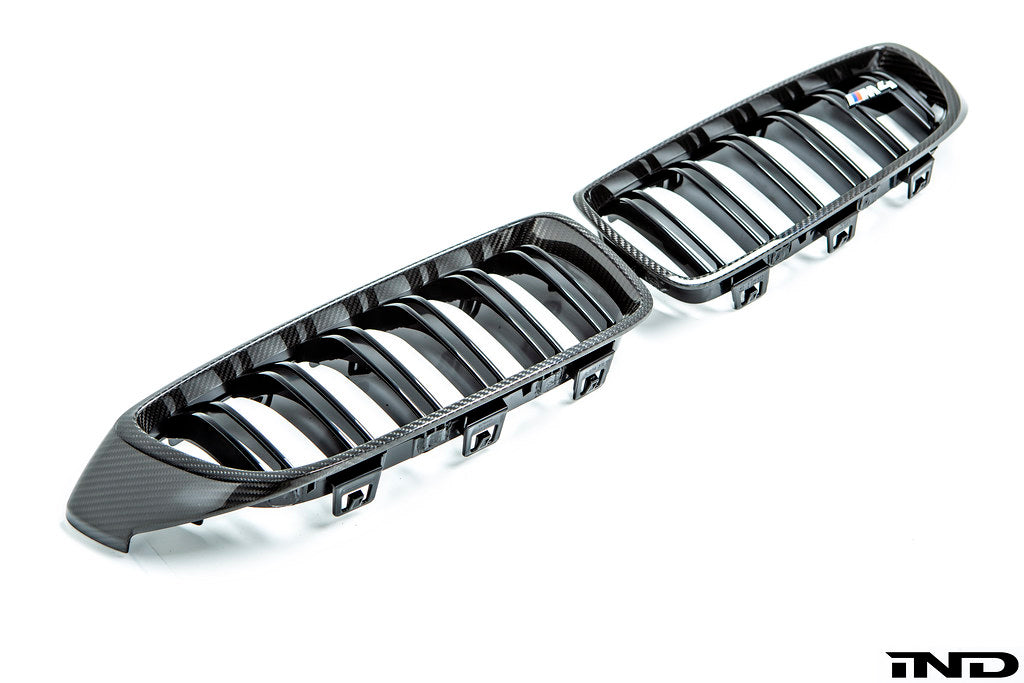 IND Carbon Fiber Front Grille Set for BMW F80 M3 and F82/F83 M4 featuring 2x2 carbon fiber surrounds with OEM BMW grille slats on a white background.