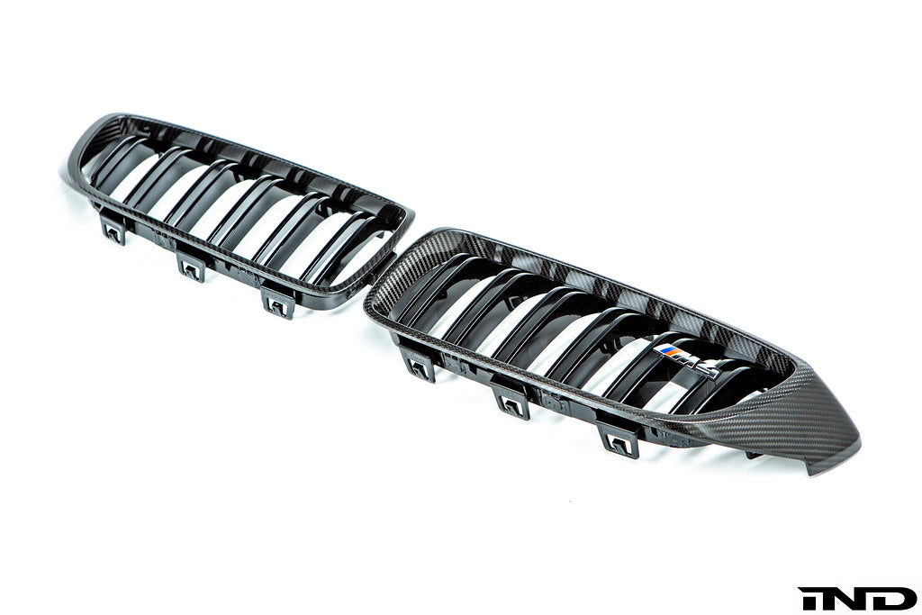 IND Carbon Fiber Front Grille Set for BMW F80 M3 and F82/F83 M4 featuring 2x2 carbon fiber surrounds with OEM BMW grille slats on a white background.