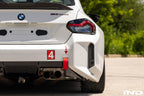 BMW G87 M2 Racing with Acexxon Rear Reflector Insert Set installed, showing the horizontal rear bumper inserts for an OEM+ appearance.