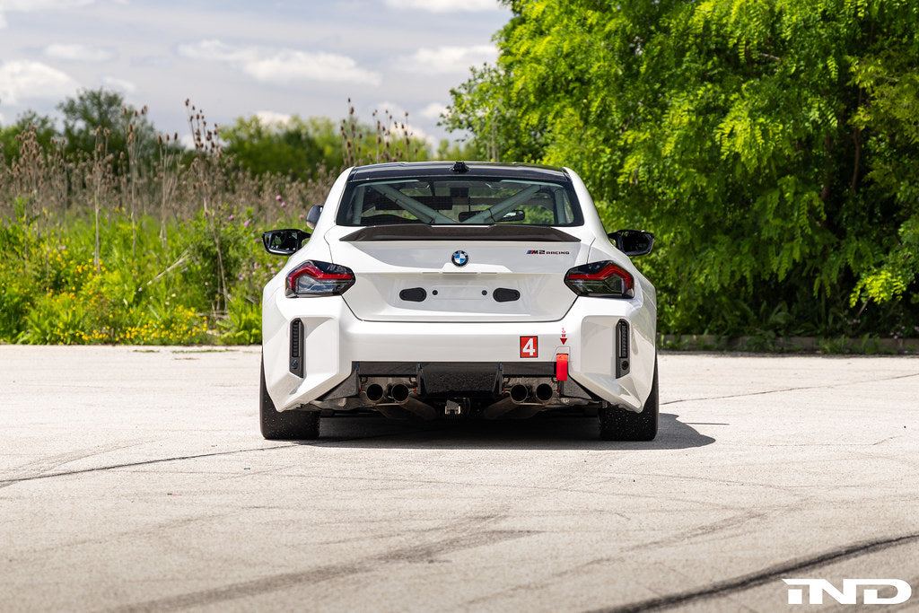 BMW G87 M2 Racing with Acexxon Rear Reflector Insert Set installed, showing the horizontal rear bumper inserts for an OEM+ appearance.