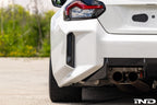BMW G87 M2 Racing with Acexxon Rear Reflector Insert Set installed, showing the horizontal rear bumper inserts for an OEM+ appearance.