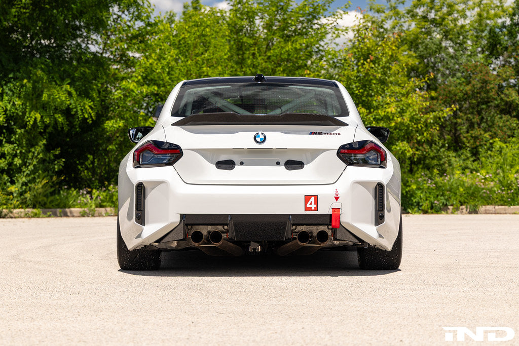 BMW G87 M2 Racing with Acexxon Rear Reflector Insert Set installed, showing the horizontal rear bumper inserts for an OEM+ appearance.