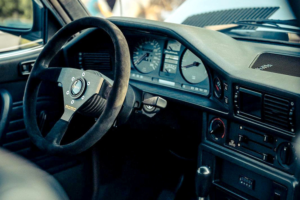 CANchecked MFD28 Gen2 2.8-inch multi-function display installed in the dashboard air vent of a left-hand drive BMW E28 M5 and 5-Series, displaying real-time vehicle data with OEM-style fitment.