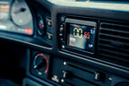 CANchecked MFD28 Gen2 2.8-inch multi-function display installed in the dashboard air vent of a left-hand drive BMW E28 M5 and 5-Series, displaying real-time vehicle data with OEM-style fitment.