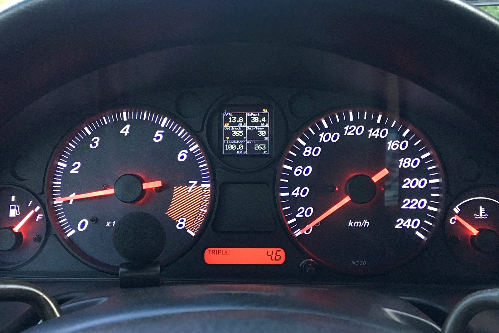 CANchecked MFA2.0 Gen2 multi-function display installed within the factory instrument cluster of a Mazda NA Miata MX-5, providing integrated performance monitoring, vehicle diagnostics, and customizable real-time data display for LHD and RHD vehicles.