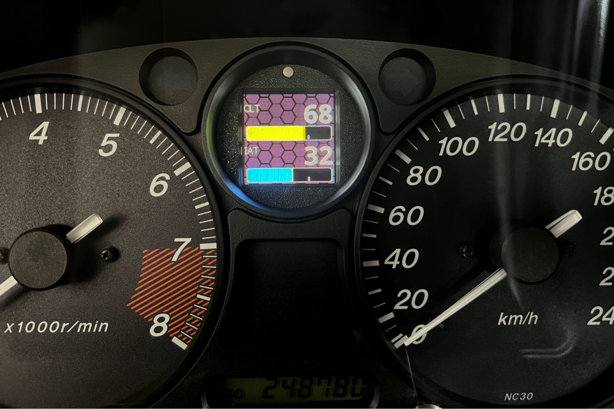 CANchecked MFA2.0 Gen2 multi-function display installed within the factory instrument cluster of a Mazda NA Miata MX-5, providing integrated performance monitoring, vehicle diagnostics, and customizable real-time data display for LHD and RHD vehicles.