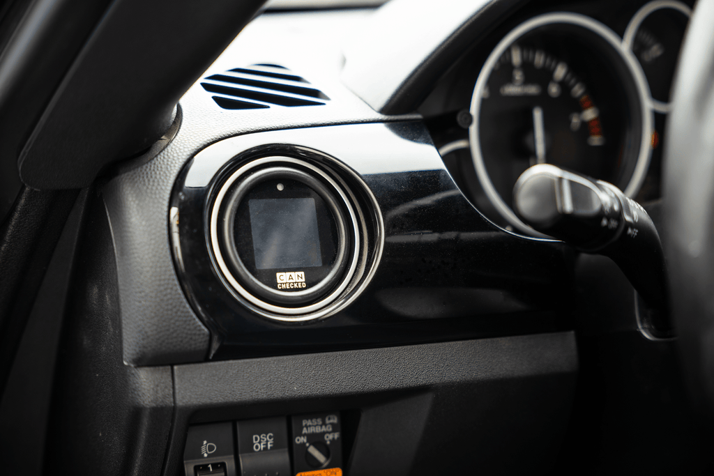 CANchecked MFD15 Gen2 1.5-inch multi-function display installed in a Mazda NC Miata MX-5 interior, providing real-time vehicle diagnostics, performance monitoring, and customizable data display through a vehicle-specific integration.