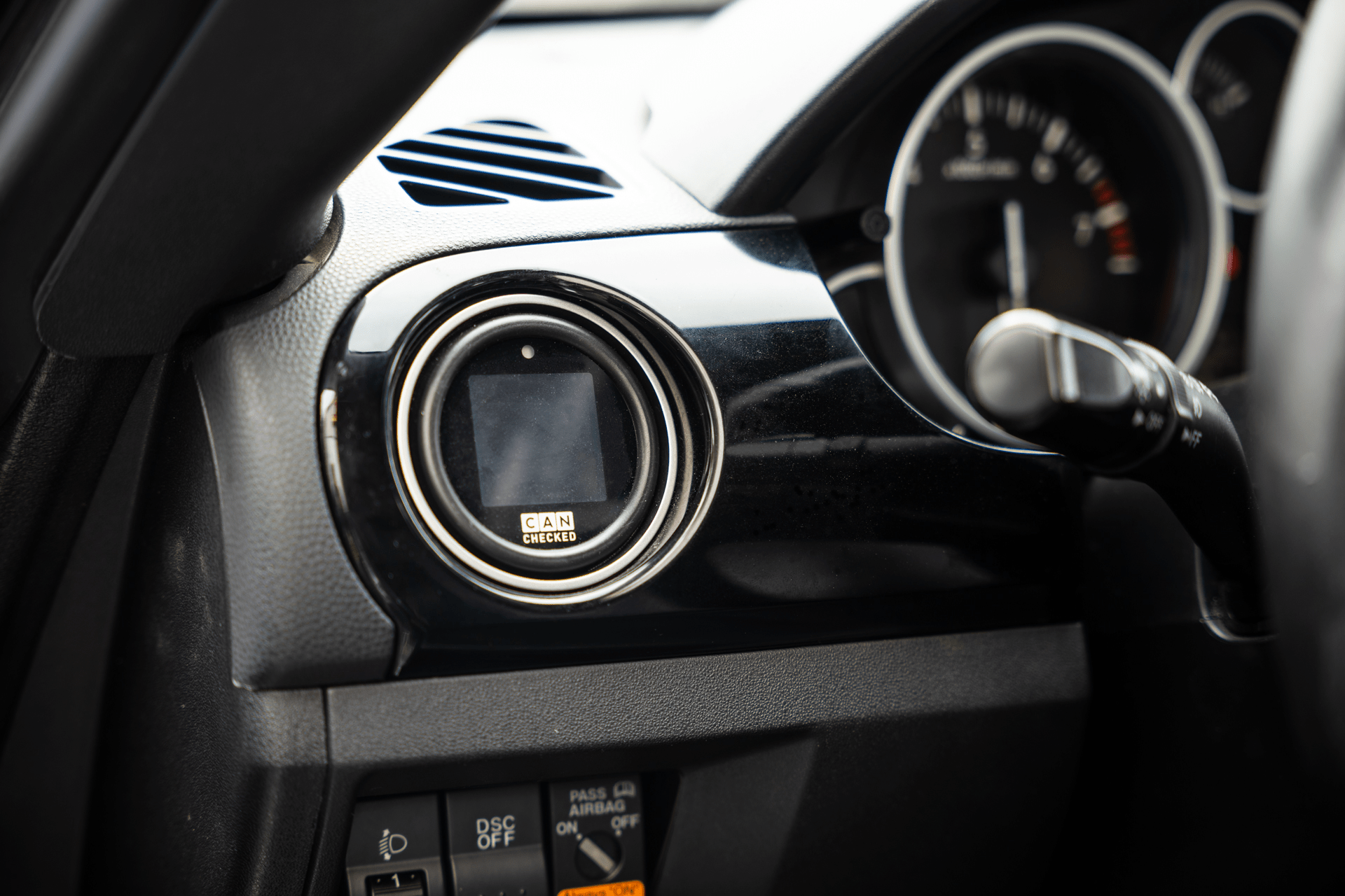 CANchecked MFD15 Gen2 1.5-inch multi-function display installed in a Mazda NC Miata MX-5 interior, providing real-time vehicle diagnostics, performance monitoring, and customizable data display through a vehicle-specific integration.