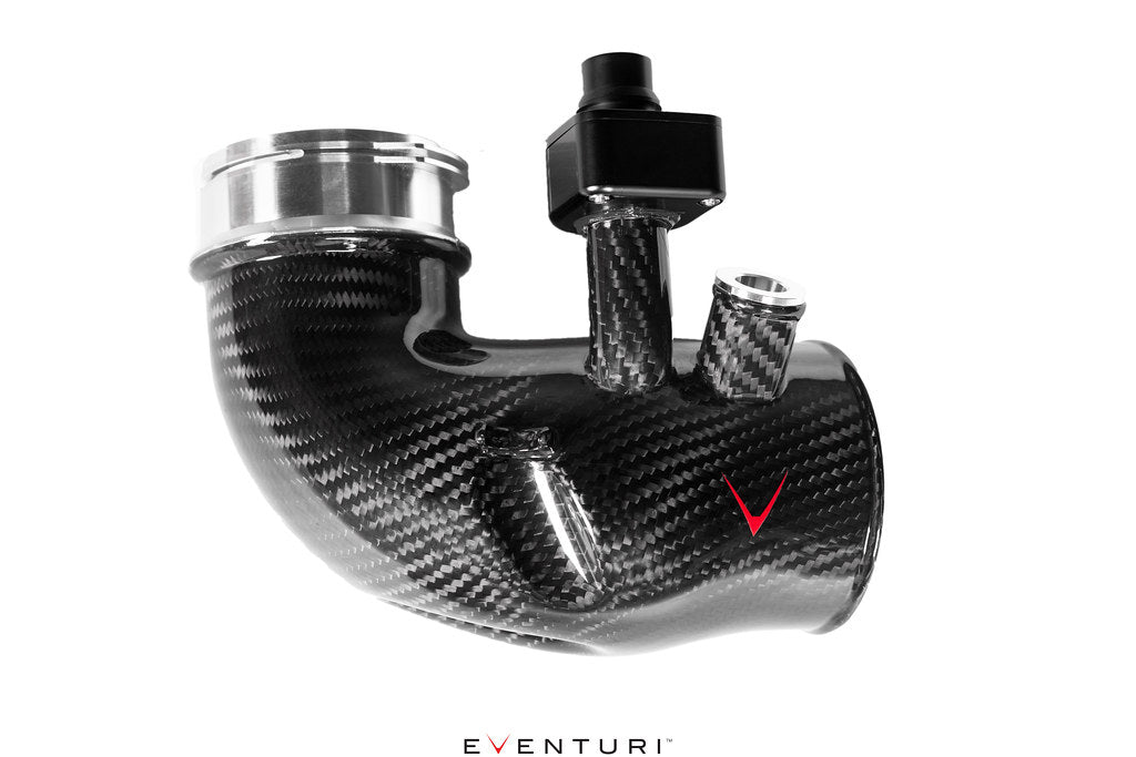 Close-up of Eventuri carbon turbo inlet set for BMW G90 G99 M5 S68, showcasing glossy fittings and high-performance design.