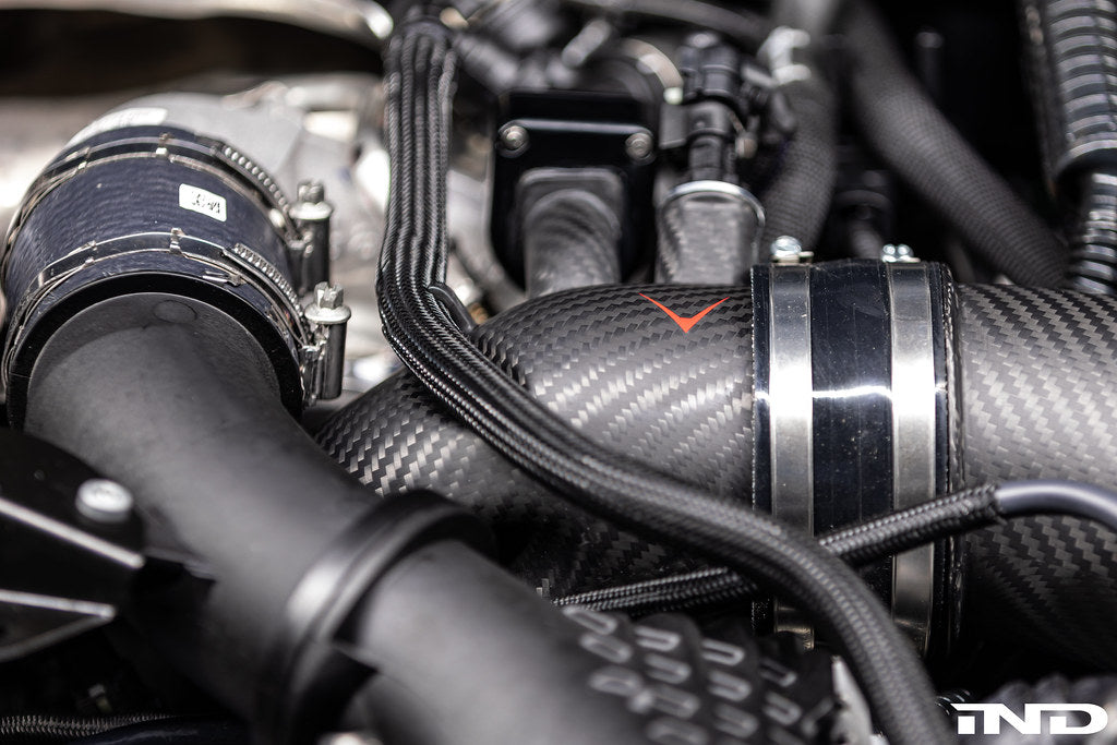 Close-up of Eventuri carbon turbo inlet set installed on BMW G90 G99 M5 (S68) showing matte finish and detailed performance components.