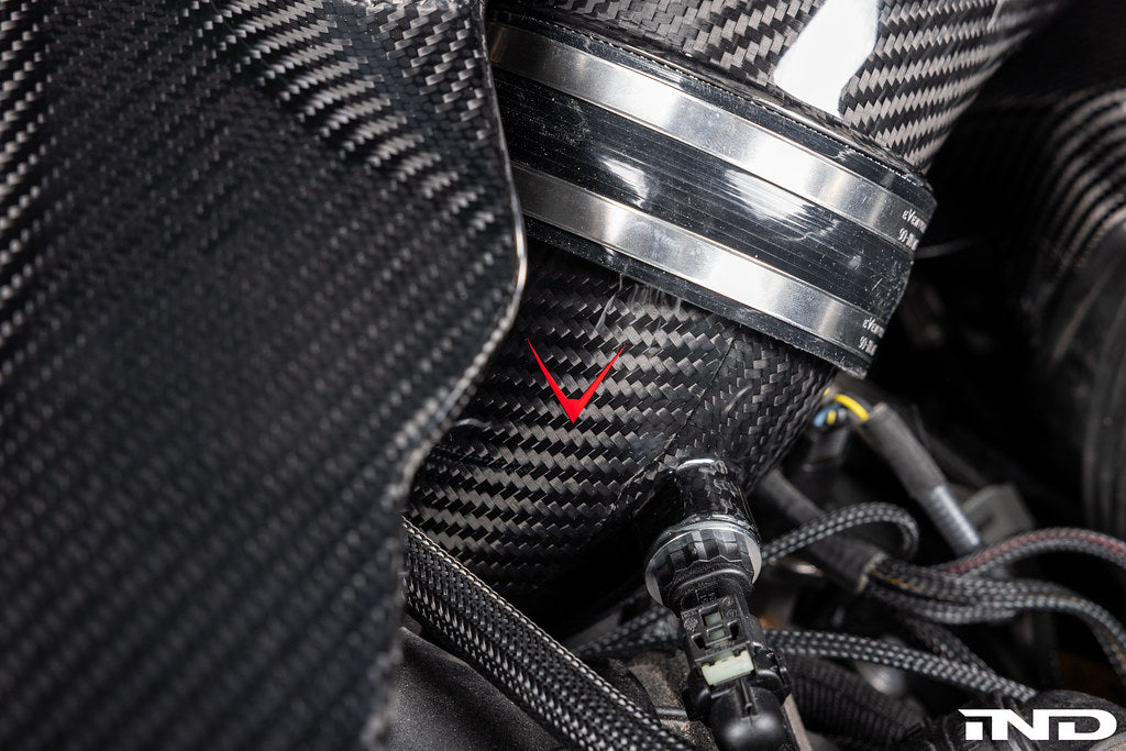Close-up of the Eventuri F9X X5M X6M G09 XM M60i LCI carbon turbo inlet set installed on a BMW engine for performance enhancement.