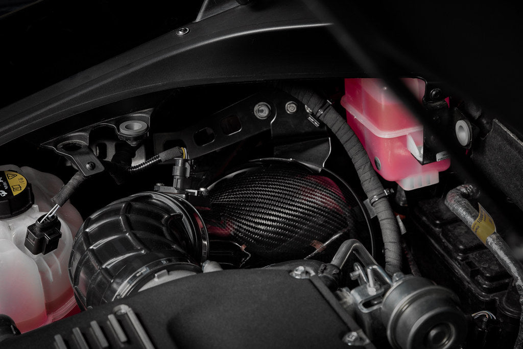 Eventuri Lotus Emira V6 black carbon intake system installed, showcasing sleek design and performance-enhancing components.