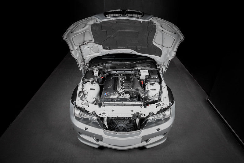 Overhead view of a BMW Z3M with the hood open, showcasing the Eventuri Hybrid Carbon Airbox System and complete carbon intake assembly installed on the S54 engine.