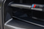 TREVORA G8X M3 M4 pre-preg carbon fiber foam crash bar cover on exterior of vehicle, showcasing sleek dark carbon fiber finish.