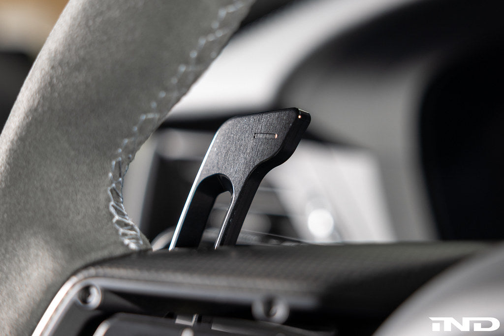 MAED Porsche 911 (992) billet magnetic shift paddle set installed in interior, showing sleek metal design on steering wheel.