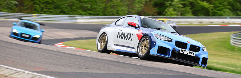 MMX BMW G87 M2 driving through the famous Nürburgring Karussell during high-performance track testing and vehicle development