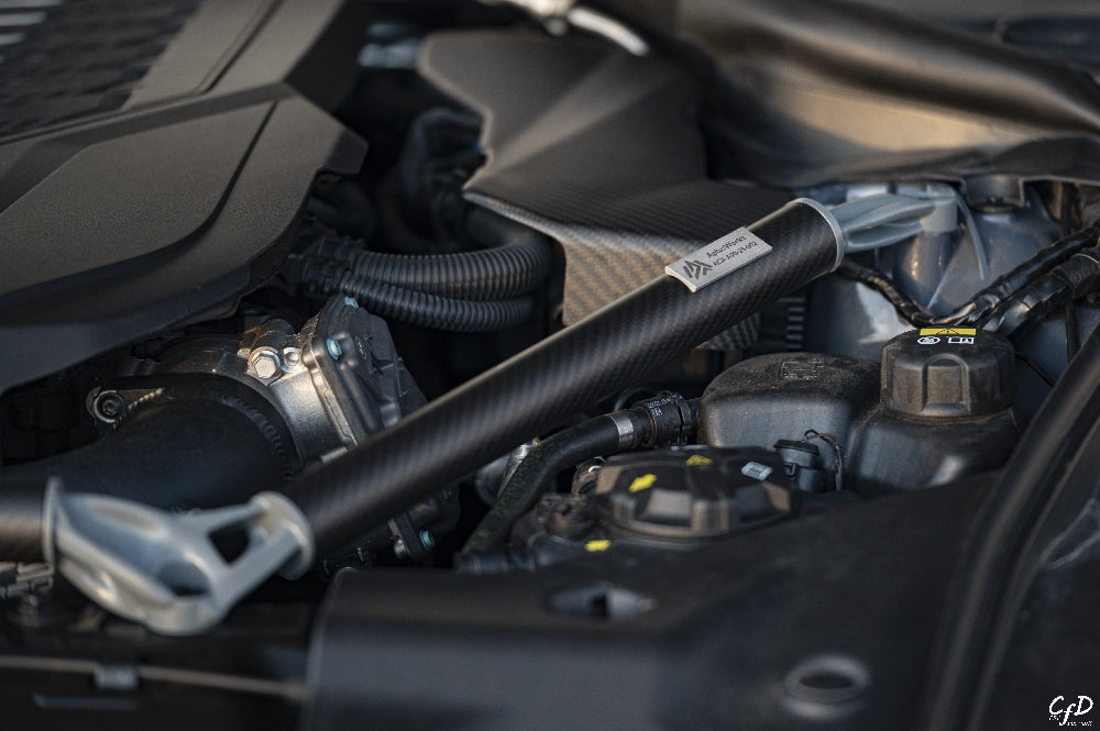 AptusWorks ACX A90 A91 MKV Supra DMLS carbon strut brace installed in the engine bay, enhancing suspension support and stability.