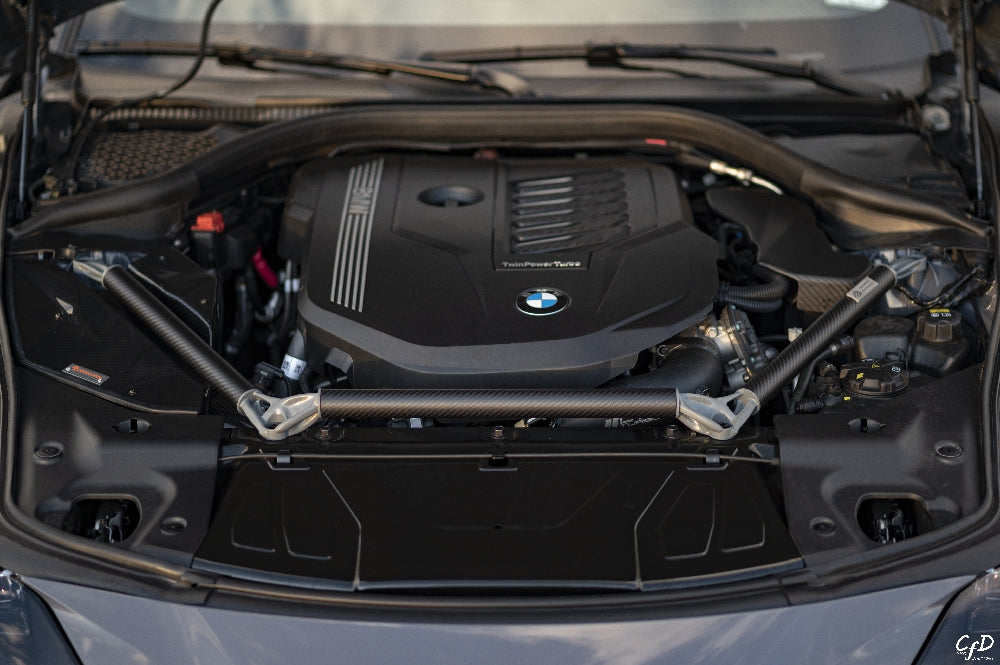AptusWorks ACX A90/A91 MKV Supra DMLS carbon strut brace installed in the engine bay, enhancing suspension stability.