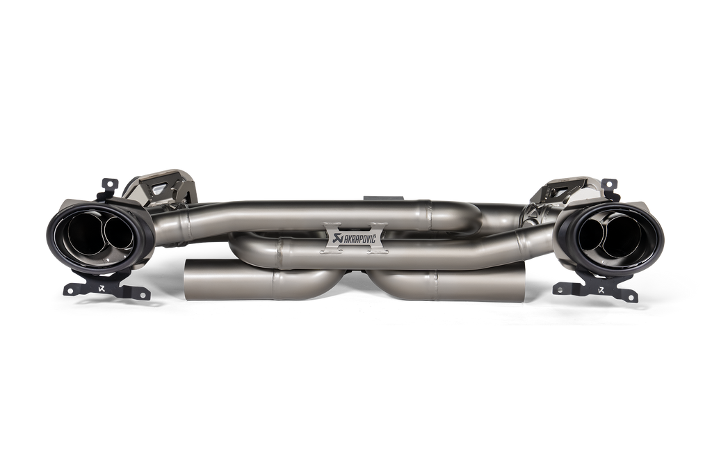 Akrapovič Porsche 992.1 Carrera GTS Dakar Slip-On Race Exhaust showing sleek black carbon fiber finish and polished exhaust tips.
