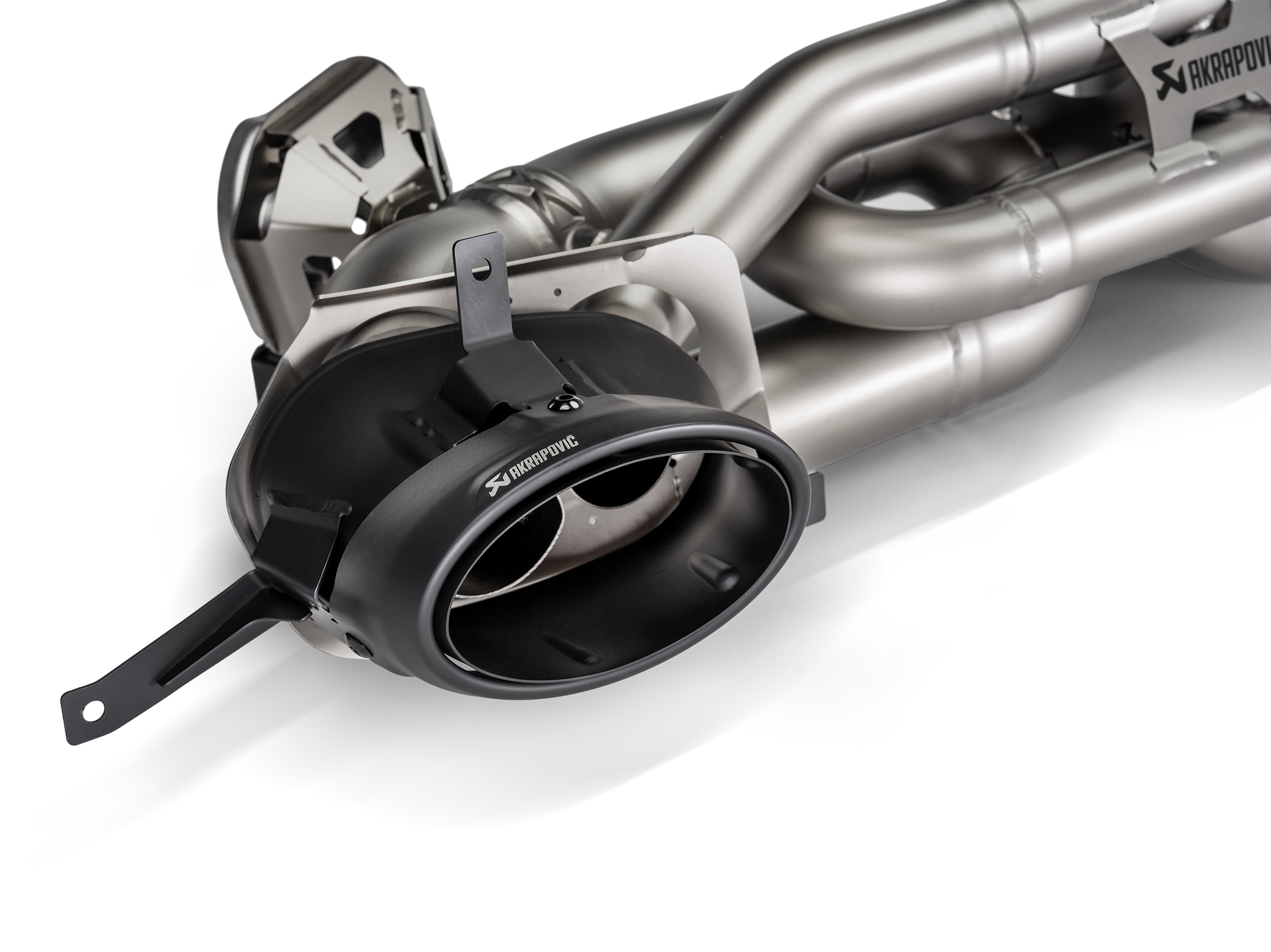 Akrapovič Porsche 992.2 Carrera T Slip-On Line exhaust system components, showcasing stainless steel pipes and muffler details.