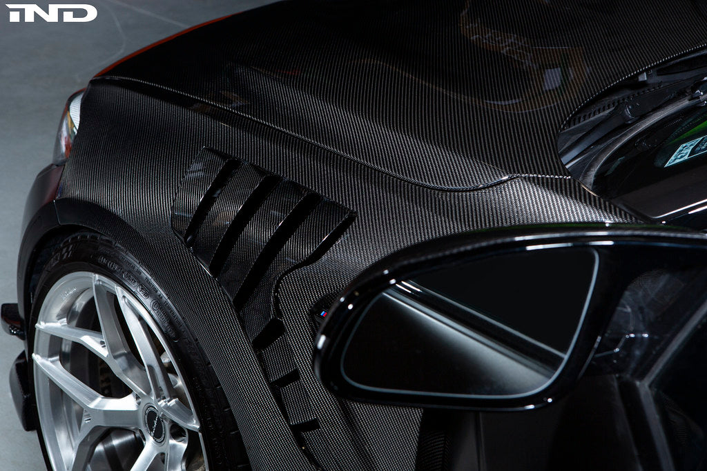 Alpha N BMW F87 M2 carbon fenders installed on exterior of car, showcasing lightweight, aerodynamic design and high-quality carbon fiber material.