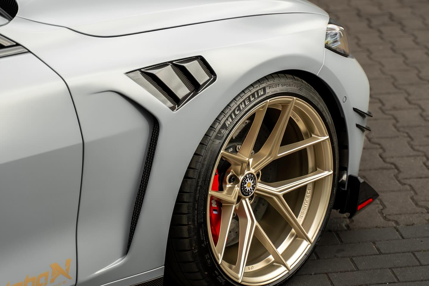 Alpha N G8X M3 M4 carbon vented front fender set installed on a BMW G8X M3 M4 exterior car part.