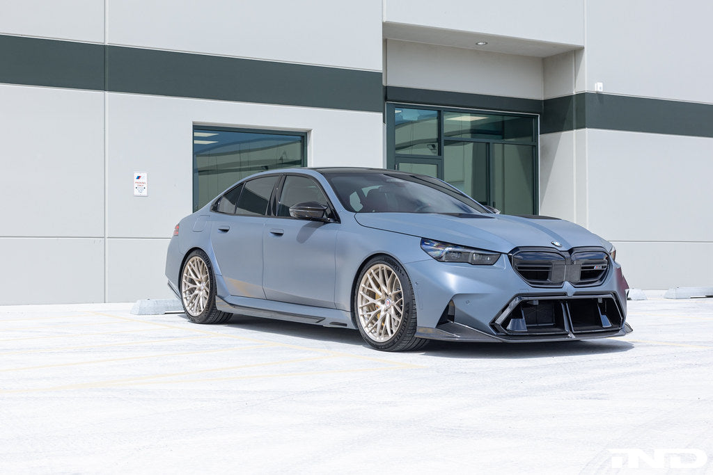Alpha N M5 carbon front splitter set installed on a BMW G90/G99, showcasing its sleek, aerodynamic design.