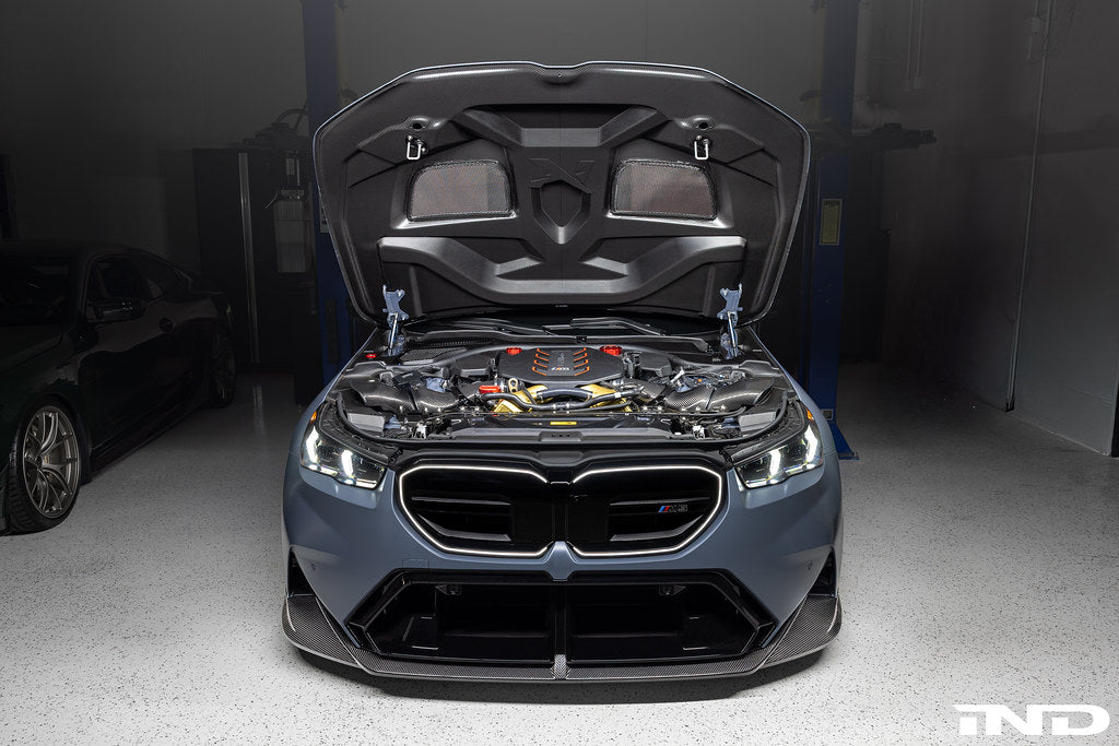 Alpha N BMW G90 G99 M5 carbon vented hood installed, showcasing sleek exterior design and lightweight carbon fiber construction.