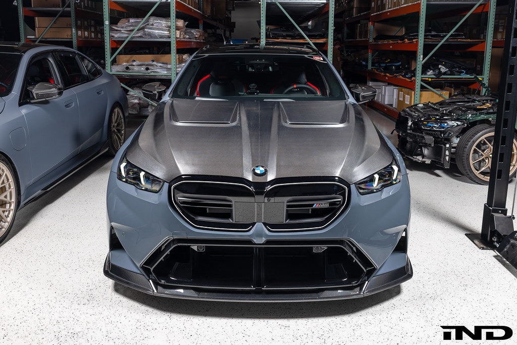 Alpha N BMW G90 G99 M5 carbon vented hood installed, showcasing sleek exterior design and lightweight vented construction.