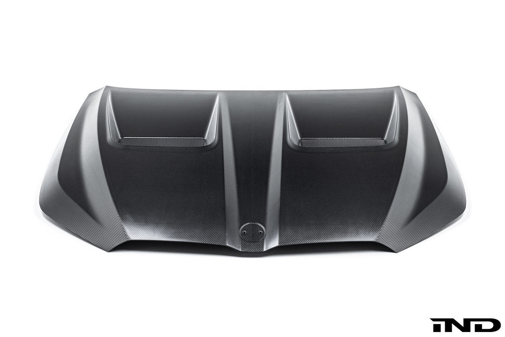 Alpha N BMW G90 G99 M5 carbon vented hood installed on vehicle, showcasing lightweight, aerodynamic exterior design against a white background.