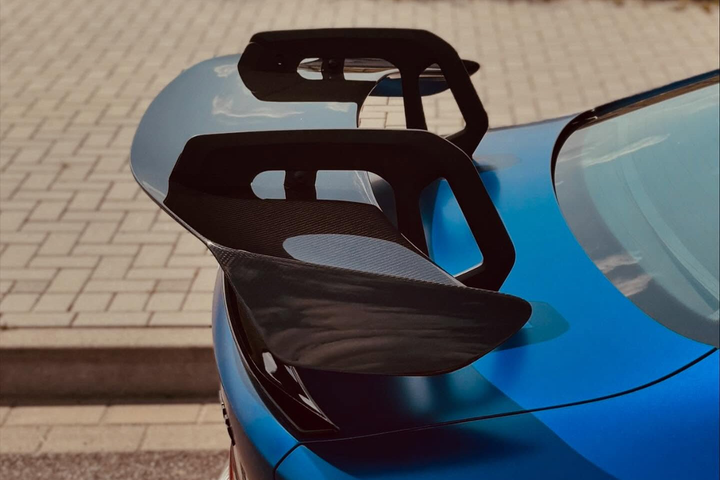 Alpha-N Carbon SN rear wing installed on a BMW M2 M3 M4, showcasing its aerodynamic exterior design and lightweight carbon construction.