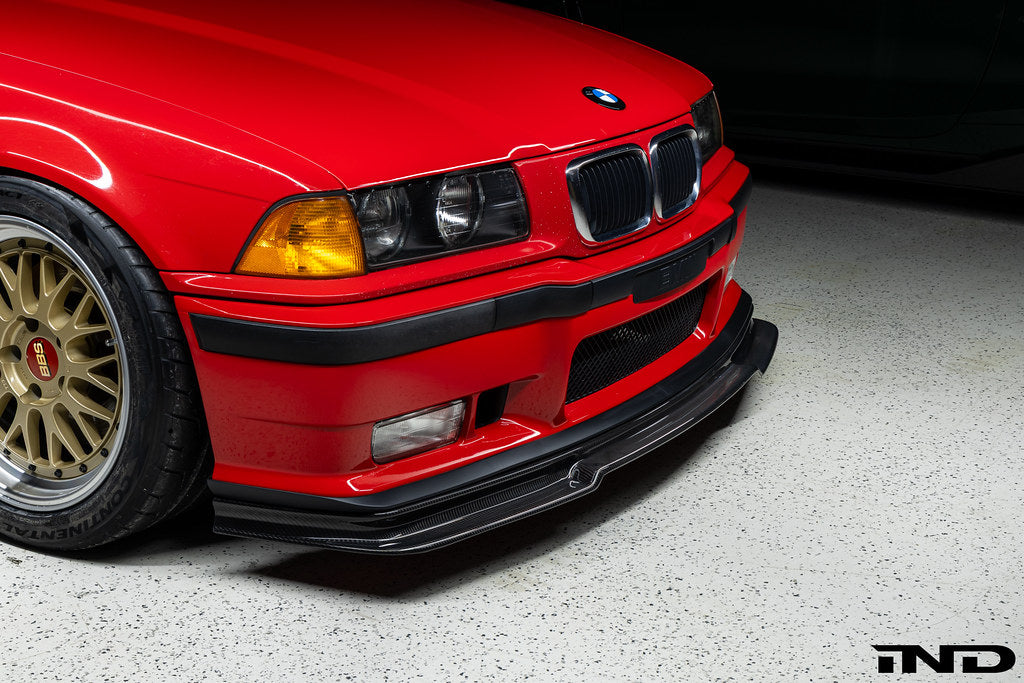 Alpha N E36 M3 Carbon GT front lip installed on red BMW E36 M3, exterior car modification with aerodynamic styling.