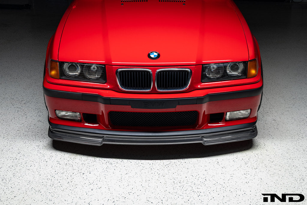 Alpha N E36 M3 Carbon GT front lip installed on red E36 M3, showcasing exterior automotive styling and aerodynamic enhancement.
