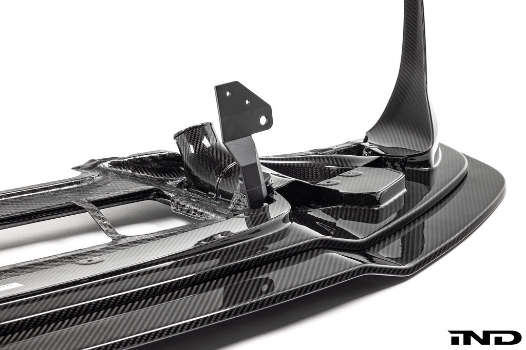 Alpha-N F87 M2 Competition CS Carbon Corse front splitter mounted on a car, showcasing its aerodynamic design and carbon fiber finish.