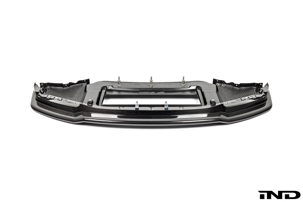 Alpha N G87 M2 Carbon Corse front splitter mounted on a car, showcasing its aerodynamic design on a white background.