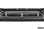 Alpha N G87 M2 Carbon Corse front splitter mounted on a car, showcasing its sleek white carbon fiber design and aerodynamic features.