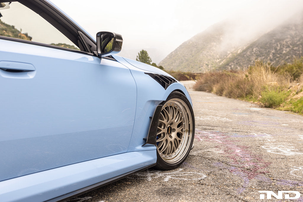 Alpha-N G87 M2 Carbon Vented Front Fender Set V4 with Blades installed on a BMW M2, showcasing lightweight carbon fiber construction.